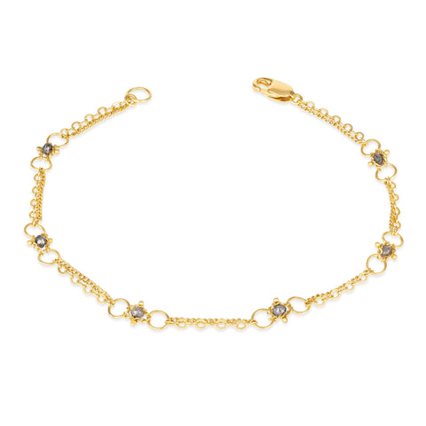 This delicate 18k yellow gold chain bracelet is dotted with grey diamond beads throughout. The bracelet is finished with a lobster clasp closure.