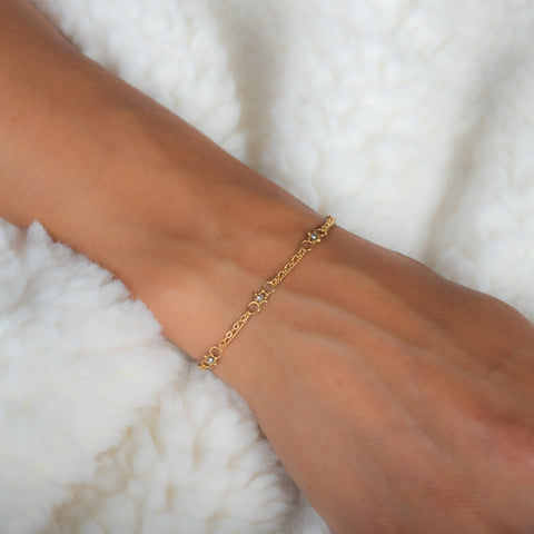 This delicate 18k yellow gold chain bracelet is dotted with grey diamond beads throughout. The bracelet is finished with a lobster clasp closure.