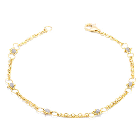 This delicate 18k yellow gold chain bracelet is dotted with silver diamond beads throughout. The bracelet is finished with a lobster clasp closure.