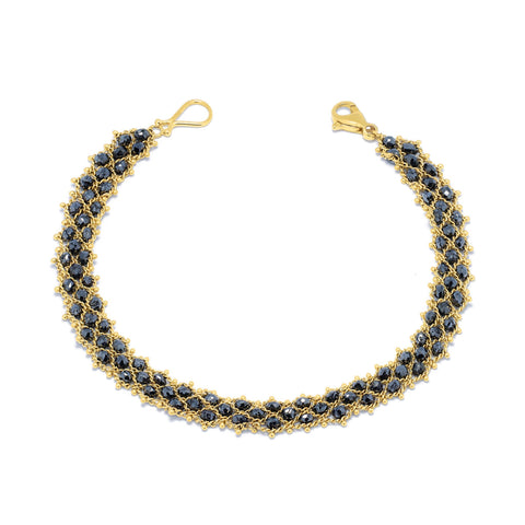 This 18k yellow gold chain bracelet features three rows of woven black diamonds. The bracelet is finished with a lobster clasp closure.
