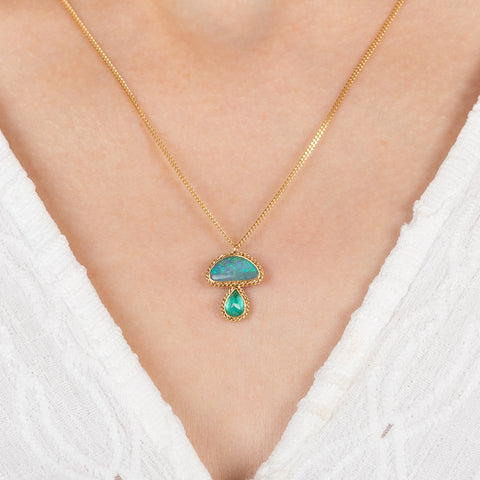 Gold necklace with a mushroom pendant on a person