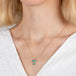 Gold necklace with a mushroom pendant on a person