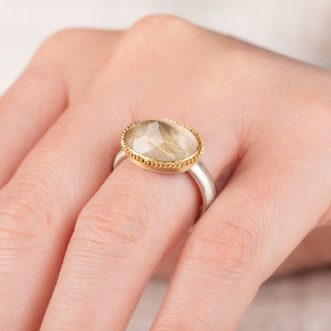 Ring with rutilated quartz stone with an 18k gold bezel and sterling silver band