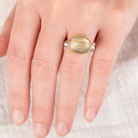 Ring with rutilated quartz stone with an 18k gold bezel and sterling silver band