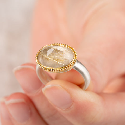 Ring with rutilated quartz stone with an 18k gold bezel and sterling silver band