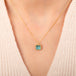 A gold chain necklace with a square pendant featuring an apatite stone set in an 18k bezel, worn on a person's neck.