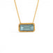 A gold chain necklace with a rectangular, light blue aquamarine gemstone pendant, framed by a textured gold bezel, shown against a plain white background.