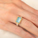 Handmade ring featuring an aquamarine gemstone set in an 18k gold bezel and paired with a sterling silver band, worn on a person's hand.