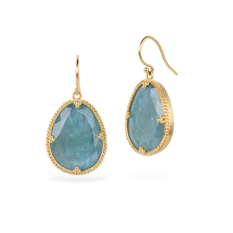 Gold earrings with aquamarine gemstones on a white background