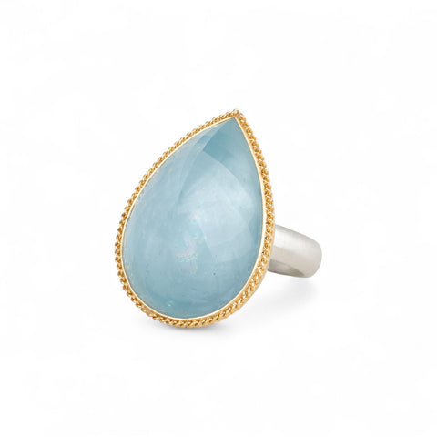Aquamarine ring with gold bezel and sterling silver band on white background