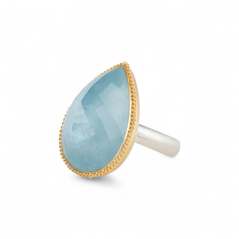Aquamarine ring with gold bezel and sterling silver band on white background