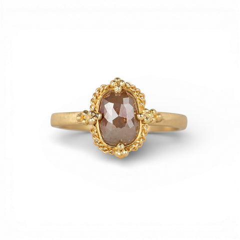 Gold ring with a brown diamond on a white background