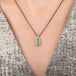 Australian opal doublet necklace with 18k gold bezel and oxidized silver chain, worn on a person's neck.