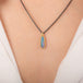 Handmade necklace featuring an Australian opal doublet stone set in an 18k gold bezel and paired with an oxidized silver chain worn on a model's neck.
