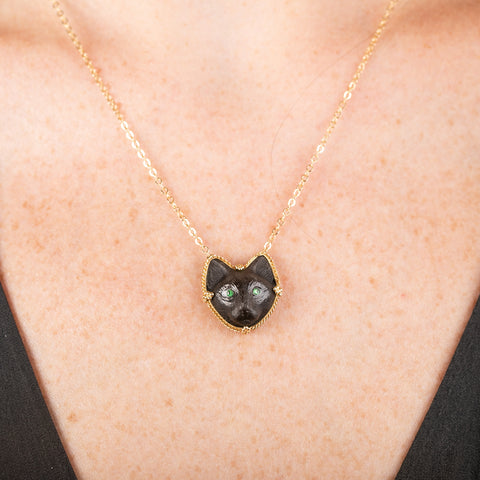 Necklace with a black cat pendant on a person's neck