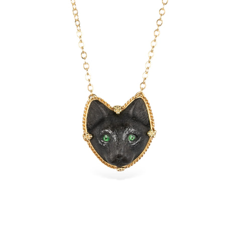 Hand-carved black cat pendant necklace with gold chain on a white background