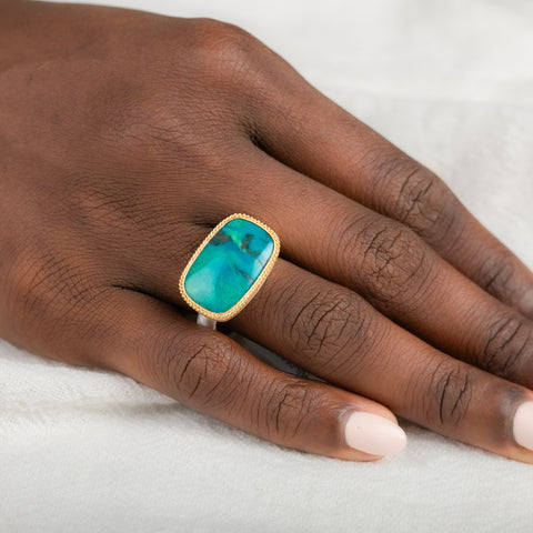 Gold and silver ring with gem silica gemstone on a person's finger