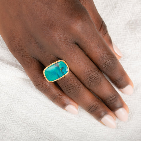 Gold and silver ring with gem silica gemstone on a person's finger