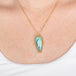 Blue opal petrified wood pendant necklace with gold setting on a person