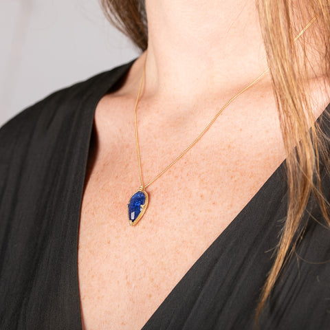 Handmade gold necklace with a blue tanzanite teardrop pendant on a perso