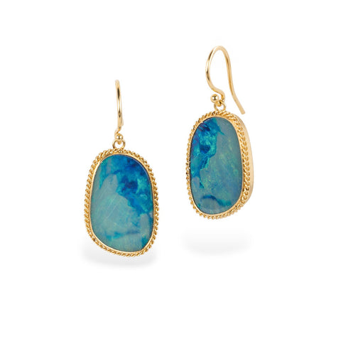 Gold earrings with blue australian opal gemsotnes on white background