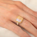 Handmade ring featuring a boulder opal gemstone set in an 18k gold bezel and paired with a sterling silver band, worn on a person's finger.