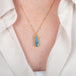 Handcrafted boulder opal and 18k gold necklace on a person
