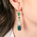 Gold earrings with chrysocolla, emerald and apatite stones worn on a person