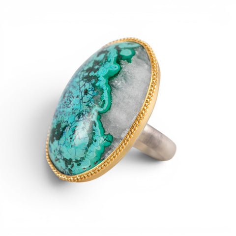 A gold and silver ring featuring a chrysocolla in quartz gemstone, shown against a white background.
