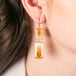 Citrine gemstone earrings in gold worn by a person