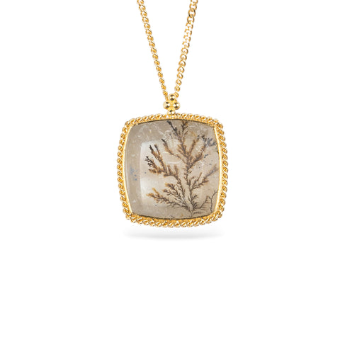 Gold necklace featuring a dendritic stone against a white background