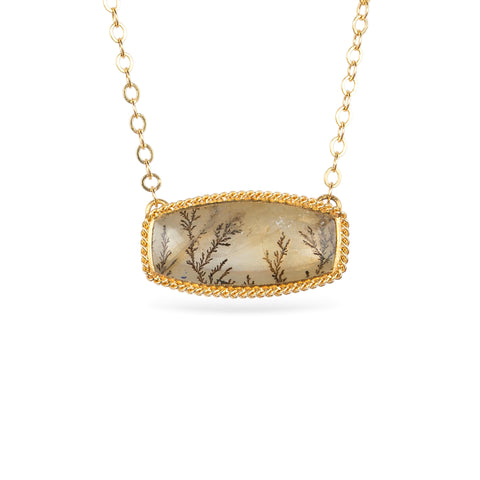 Gold necklace featuring a dendritic quartz stone against a white background.
