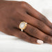 Gold and silver ring with a dendritic quartz stone on a person's hand