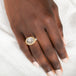Gold and silver ring with a dendritic quartz stone on a persons hand
