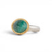 An oval emerald gemstone ring set in a gold bezel, with a sterling silver band, shown against a plain white background.