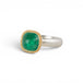 A ring featuring a cushion-cut emerald gemstone in a gold bezel setting, paired with a silver band, shown against a plain white background.