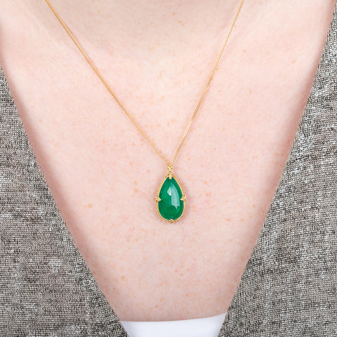 Gold necklace with Emerald teardrop worn by a model
