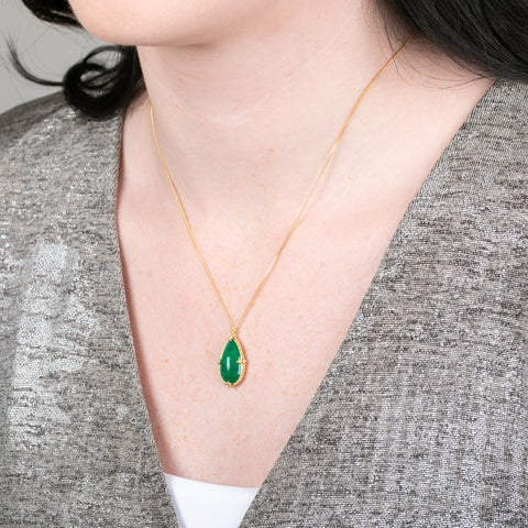 Gold necklace with Emerald teardrop worn by a model