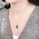 Gold necklace with Emerald teardrop worn by a model