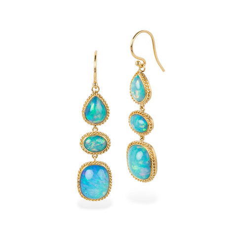Gold earrings with turquoise gemstones on a white background