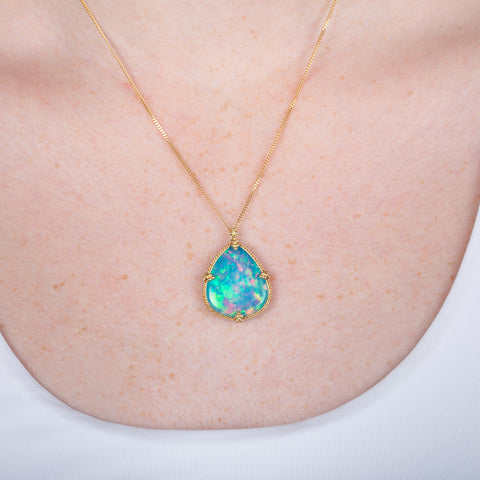 Ethiopian opal pendant necklace with gold setting on a person