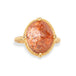 Gold ring with a sunstone stone on a white background