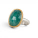 An oval emerald gemstone ring with a textured gold bezel and a sterling silver band, shown on a plain white background.