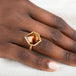 Ring with a tourmaline gemstone on a hand against a white background