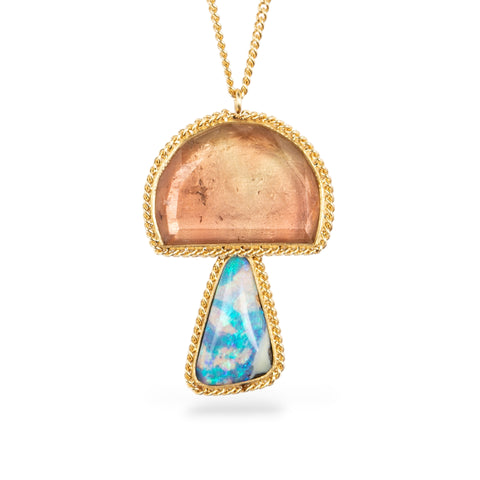 Gold pendant with a mushroom design combining a tourmaline stone with a boulder opal stone on a white background
