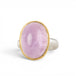 A ring featuring a large oval kunzite stone, set in a gold textured bezel with a sterling silver band.