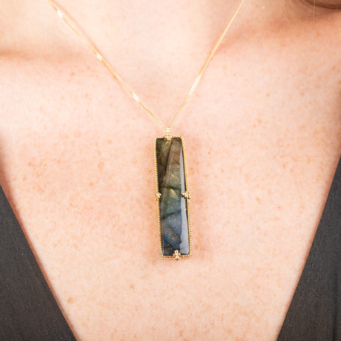 18k gold necklace with a Labradorite pendant worn on a person's neck.