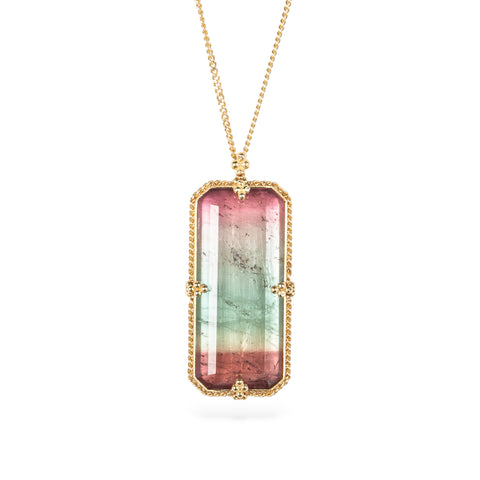 Handmade ecklace with a watermelon tourmaline gemstone set in a gold bezel on a white background
