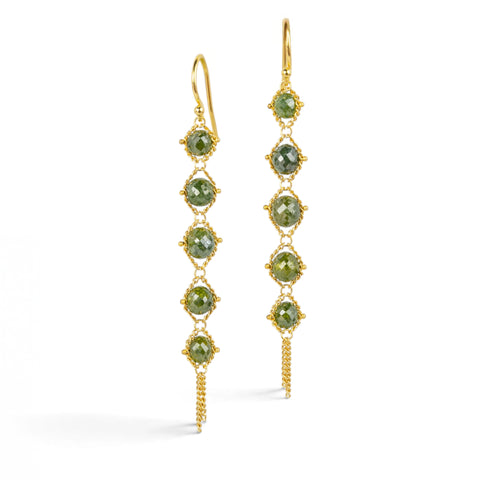 Gold earrings featuring rows of glistening green diamonds, shown against a white background.