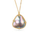 Gold necklace featuring a mabe pearl stone against a white background